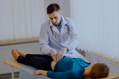 Gastroenterology provider performing an abdominal examination on a patient during a digestive health consultation