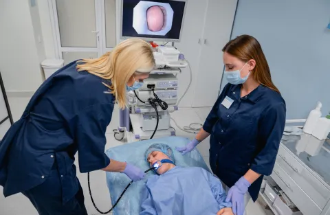 Medical staff performing an endoscopy procedure on a patient in a gastroenterology clinic